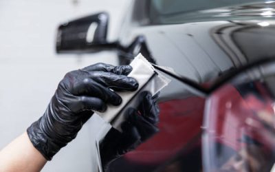 The process of applying a nano-ceramic coating on the car's fender by a male worker with a sponge and special chemical composition to protect the paint on the body from scratches, chips and damage.